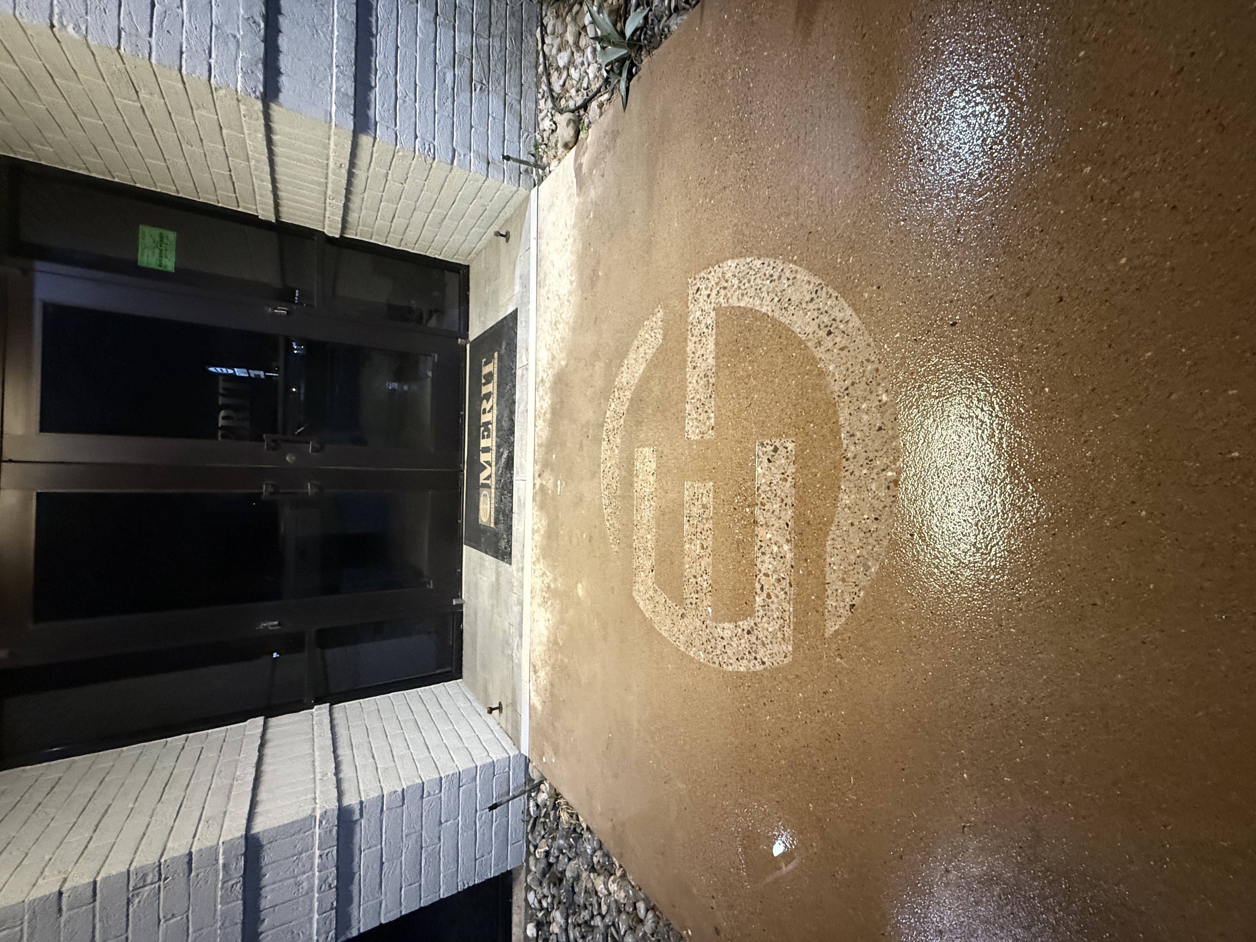 Merit Construction entrance with engraved logo at night